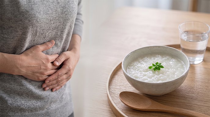 胃腸炎で腹部を押さえる人と食事